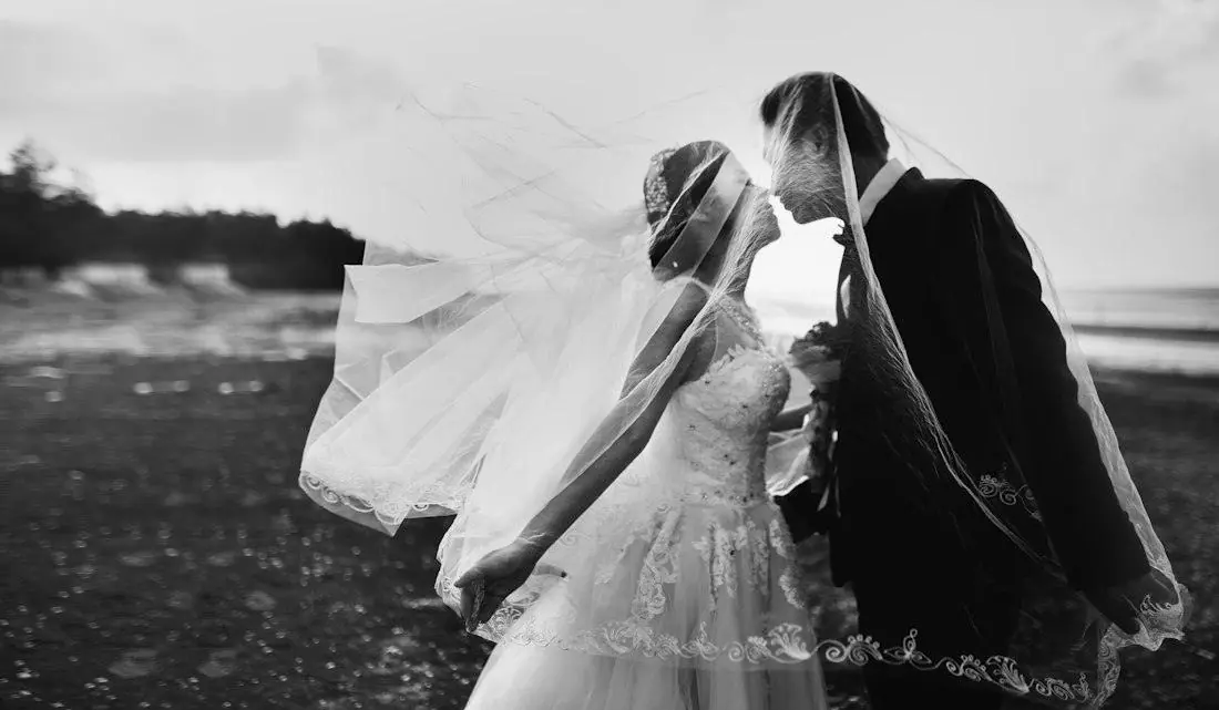 Black and white: a veil caught by the wind around a couple